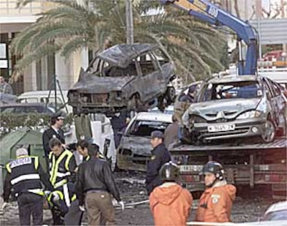 Bomberos y policías examinan los coches afectados por la explosión de Gandia.