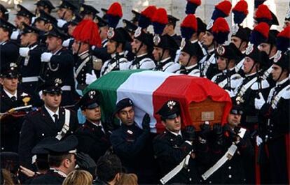 Varios <i>Carabinieri</i> introducen a hombros uno de los 19 féretros en la Basílica de San Pedro Extramuros.