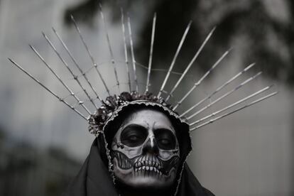 Uma mulher vestida de La Catrina espera o começo da 'Mega procissão de Catrinas', parte das celebrações do Dia dos Mortos na Cidade de México.