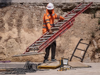 Un trabajador de la construcción se protege del sol en una obra del Eixample de Barcelona.