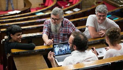 Los diputados de la CUP conversan antes de la votacion, de izquierda a derecha, Anna Gabriel, Joan Garriga y Sergi Saladie. De espaldas, Benet Salennas y Mireia Vehí.