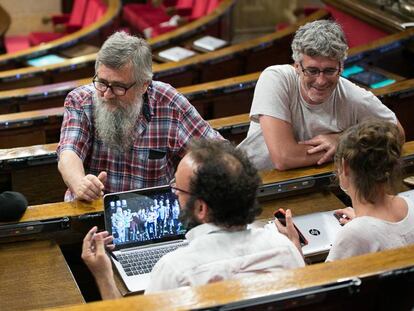 Los diputados de la CUP conversan antes de la votacion, de izquierda a derecha, Anna Gabriel, Joan Garriga y Sergi Saladie. De espaldas, Benet Salennas y Mireia Vehí.