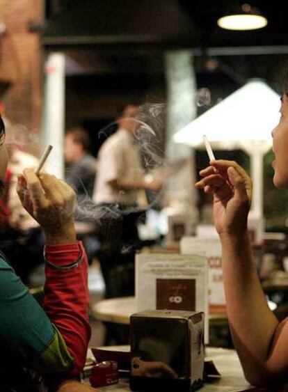 Dos mujeres fuman en una cafetería.