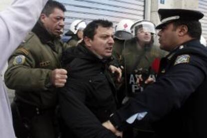 Un manifestante se enfrenta a agentes antidisturbios durante una jornada de protestas a la entrada del Ministerio de Finanzas, en Atenas.