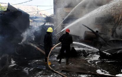 Una imagen de la agencia oficial siria SANA que muestra a dos bomberos extinguiendo el fuego.