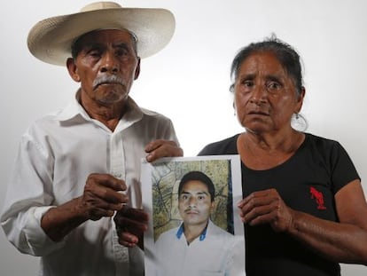 Residentes de Iguala muestran una foto de su hijo desaparecido.