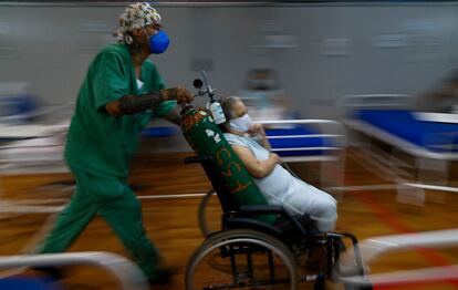 Uma paciente com covid-19 é transportada em um hospital montado em um ginásio de esportes em Santo André, São Paulo.