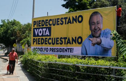 Un hombre camina junto a una imagen del candidato presidencial independiente, Rodolfo Hernández, en Pié de Cuesta. 