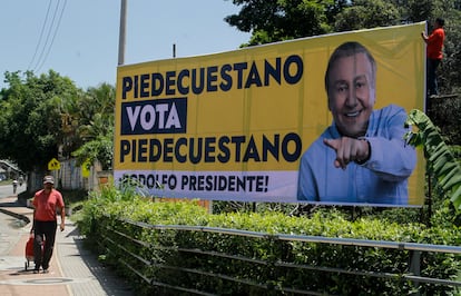 Un hombre camina junto a una imagen del candidato presidencial independiente, Rodolfo Hernández, en Pié de Cuesta.