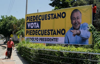 Un hombre camina junto a una imagen del candidato presidencial independiente, Rodolfo Hernández, en Pié de Cuesta. 