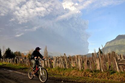 Un niño pasea en bicicleta cerca del volcán Puyehue-Cordon Caulle, en Chile. Más de 3.000 personas han sido evacuadas ante la erupción del volcán, aunque su actividad se ha visto reducida en las últimas horas.