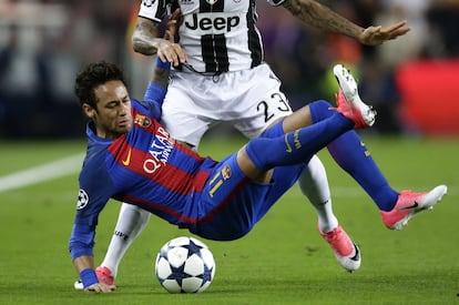 El delantero brasileño del Barcelona Neymar Da Silva cae al suelo después de una jugada con su compatriota Dani Alves, de la Juventus.