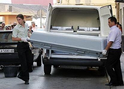 Miembros del servicio funerario trasladan el féretro con los restos de la mujer asesinada en La Línea de la Concepción.