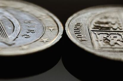 Un euro irlandés, junto a una libra esterlina.