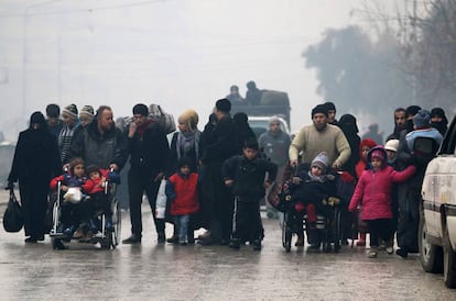 Um grupo de sírios abandona um bairro de Aleppo, em 13 de dezembro