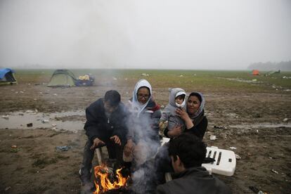 Migrantes afganos se calientan en una hoguera el campo de refugiados de Idomeni, en la frontera entre Grecia y Macedonia. 