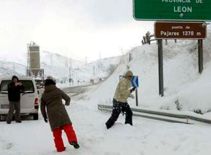 Varias personas se lanzan bolas de nieve en el Puerto de Pajares, en León, donde es necesario usar cadenas.