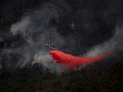 Un avión arroja retardante contra las llamas en un incendio en Málaga, en una imagen de archivo.