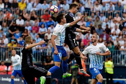 El jugador del Real Madrid, Cristiano Ronaldo, remata el balón de cabeza superando por alto al jugador del Málaga Federico Ricca.