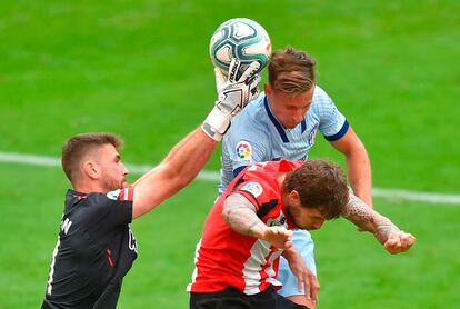 Marcos Llorente cabecea entre el defensa Íñigo Martínez y el portero Unai Simon en el Athletic-Atlético.