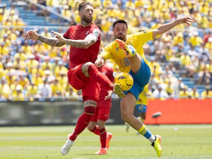 Sergio Ramos despeja el balón ante el acoso de Javi Muñoz.