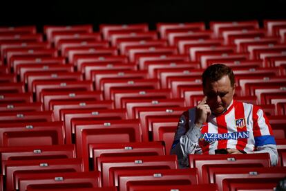 Un seguidor del Atlético consulta su teléfono al comienzo del partido en el Wanda Metropolitano.