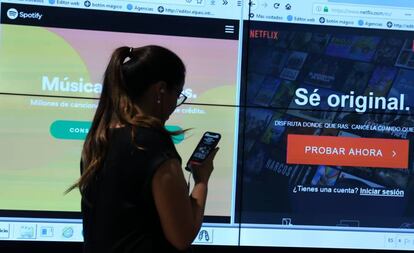 Una mujer frente a una pantalla para conectarse a Spotify y a Netflix.