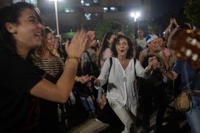 Decenas de israelíes cantan y bailan canciones hebreas esperando el regreso de los 13 rehenes a Tel Aviv, este viernes.   