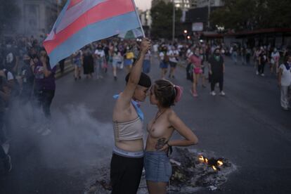 Dos mujeres, una de ellas ondeando la bandera del orgullo trans, en la rebautizada plaza de la Dignidad de Santiago de Chile.