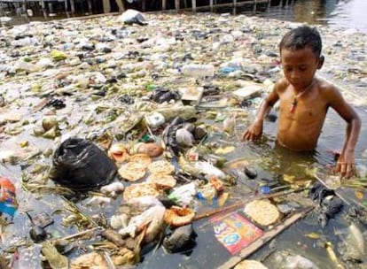 Un niño indonesio juega en una balsa de agua llena de basura en Muara Baru, al norte de Yakarta.