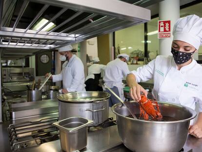 Varios alumnos de la escuela de hostelería La Cónsula, en Málaga, preparan el menú del día.