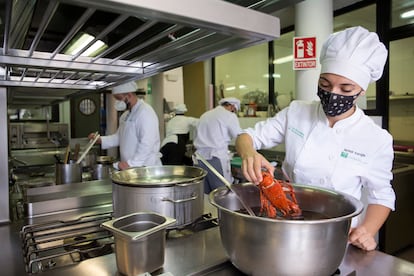 Varios alumnos de la escuela de hostelería La Cónsula, en Málaga, preparan el menú del día.