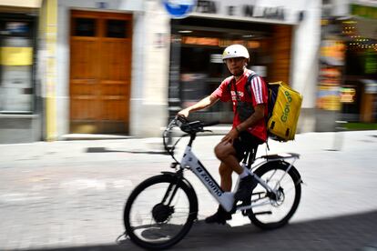 Un repartidor de Glovo pedalea por las calles de Malasaña, el 18 de julio de 2024, cuando los termómetros rebasan los 35 grados.