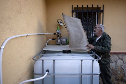 Antonio Parralejo, vecino de Can Ros (Cabrera d Anoia) junto al deposito de agua que ha instalado para evitar los cortes de suministro. 
