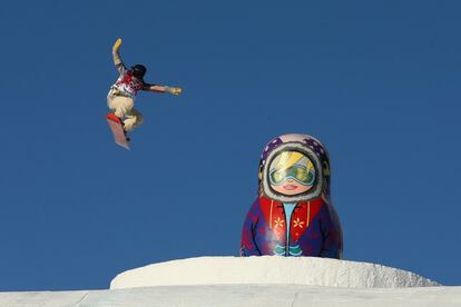 Una atleta durante los entrenamientos de Snowboard salta frente a una escultura de una matrioska en el parque de Rosa Khutor.