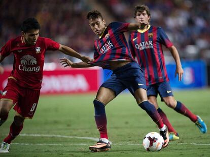 Neymar dribla al tailandés Puttinan Wannasri durante la primera mitad del encuentro en el estadio Rajamangala de Bangkok.