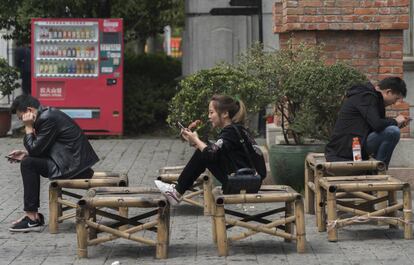 Três pessoas interagindo em Wuhan, na China.