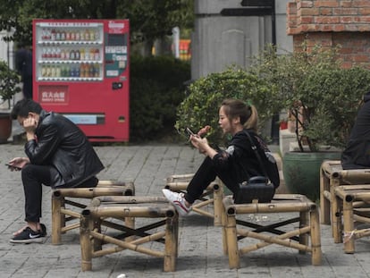 Três pessoas interagindo em Wuhan, na China.