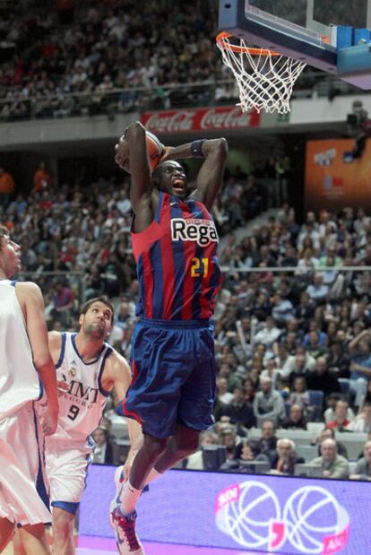 El azulgrana Ndong salta para machacar el aro del Madrid ante la mirada de Felipe Reyes y Tomic.