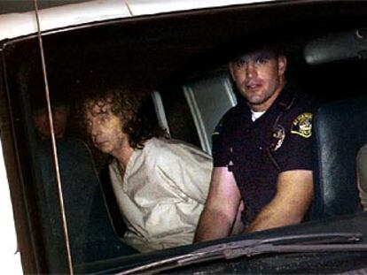 Phil Spector, acompañado de un policía de Los Ángeles tras su detención. A la izquierda, la actriz Lana Clarkson.