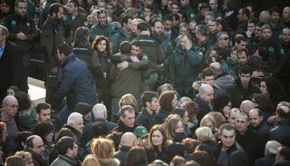 Companys i familiars dels agents assassinats es consolen en finalitzar el funeral.