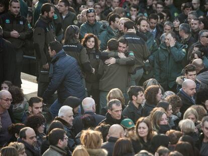 Companys i familiars dels agents assassinats es consolen en finalitzar el funeral.