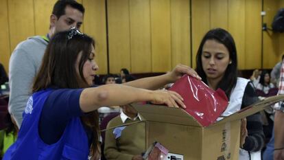Funcionarios de la autoridad electoral abren una caja con actas de las presidenciales en Quito.