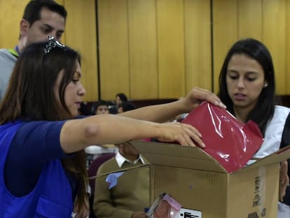 Funcionários da autoridade eleitoral abrem uma caixa com atas da eleição presidencial em Quito.