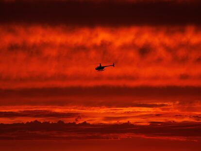 A helicopter travels south along the coast after sunset over the ocean as Hurricane Hilary approaches Del Mar, California, U.S., August 19, 2023.