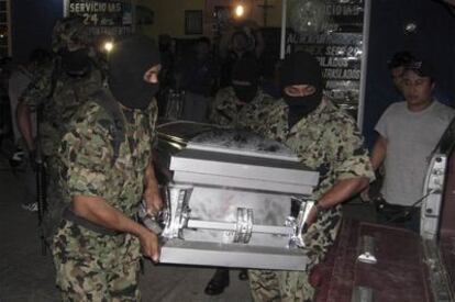 Miembros de una unidad especial de la Marina portan el ataúd de una de las víctimas de la matanza.