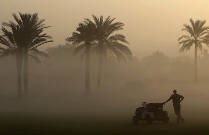 Un caddy espera a primera hora de la mañana a que comience el campeonato femenino de Golf en Dubai, en los Emiratos Árabes Unidos.