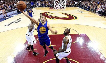 Curry se dispone a anotar anta la mirada de James en uno de los partidos de la final de este año de la NBA.