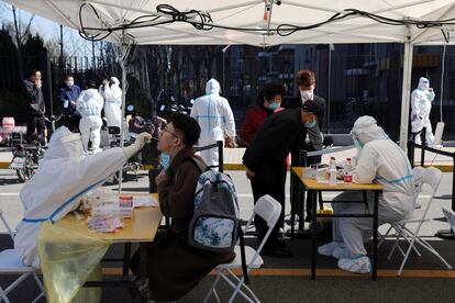 Un sanitario realiza un test PCR a un hombre durante una prueba masiva, este lunes en Pekín. 