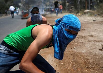 Dos palestinos, con la cabeza cubierta, se enfrentan con las tropas israelíes en Beita (Franja de Gaza).